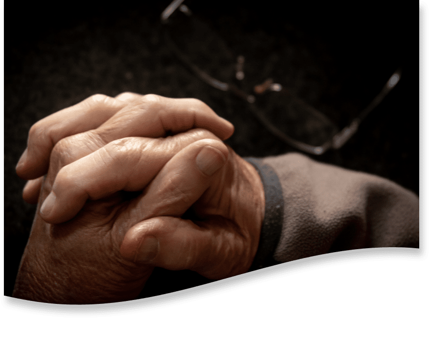 A patient and caregiver holding hands.
